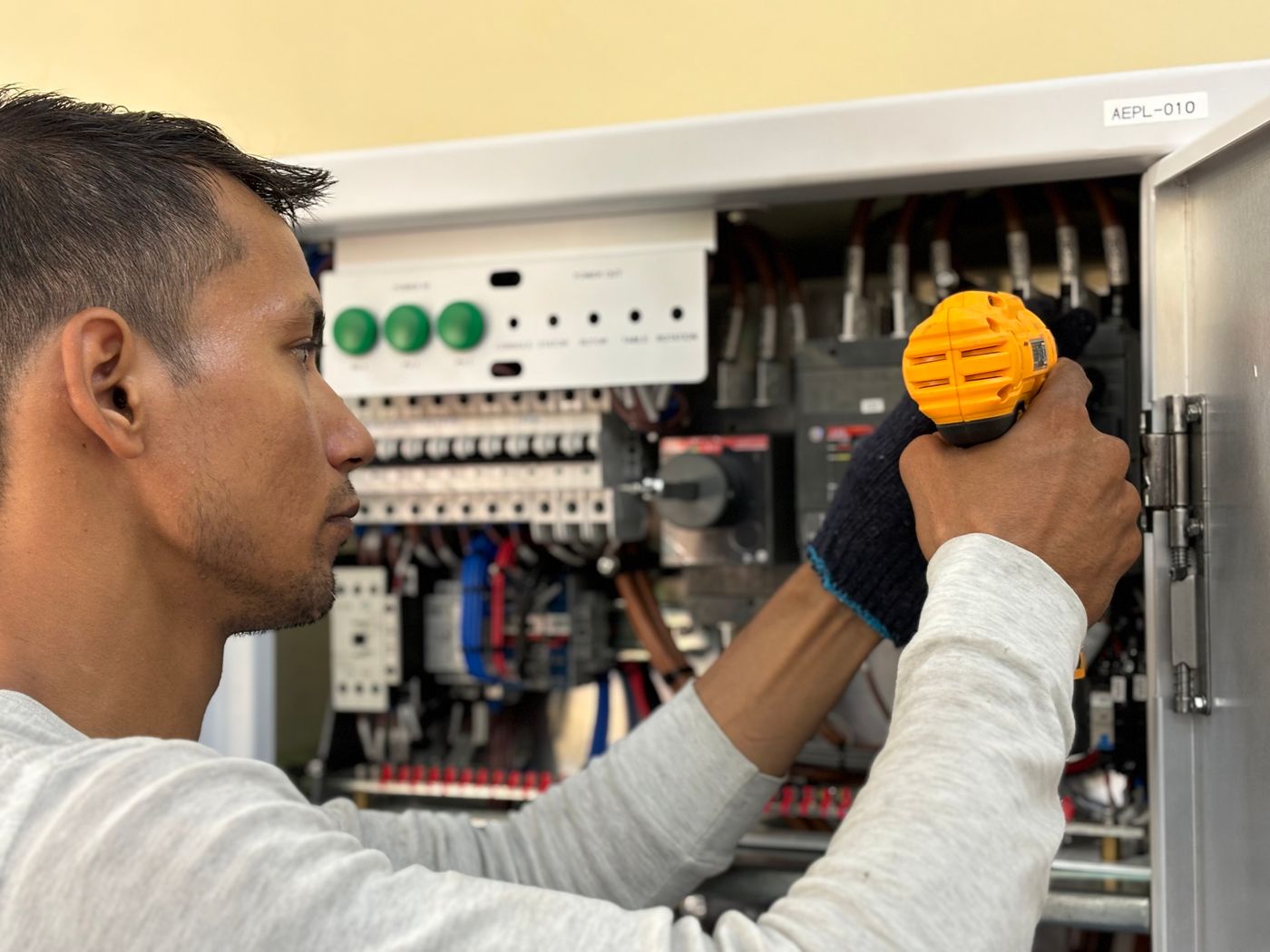 Electrician lucrând la un tablou electric deschis